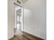 Bright hallway featuring grey-wood style floors with a glimpse into another room with a ceiling fan at 12 Brentwood Ln, Englewood, FL 34223