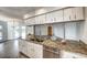 Kitchen island features granite countertops, stainless steel appliances, and white cabinets at 12 Brentwood Ln, Englewood, FL 34223