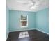 Light teal bedroom with dark wood floors and ceiling fan at 1777 Gantry Rd, North Port, FL 34288