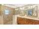 Bathroom featuring a walk-in shower, dual sinks with granite countertops, and a large mirror at 1789 Loma Linda St, Sarasota, FL 34239