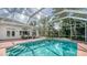 Enclosed swimming pool with steps and a seating area surrounded by lush landscaping at 1789 Loma Linda St, Sarasota, FL 34239