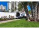 Exterior landscaping with lush green lawn, flower bed, and tropical plants near the condos at 2100 Benjamin Franklin Dr # 205, Sarasota, FL 34236