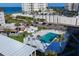 Aerial view of community swimming pool with lounge chairs, umbrellas, and tropical landscaping at 2100 Benjamin Franklin Dr # 205, Sarasota, FL 34236