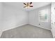 Neutral bedroom featuring plush carpet, ceiling fan, and a bright window at 3718 Mossy Limb Ct, Palmetto, FL 34221