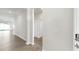 Hallway with neutral walls, wood-look flooring, and white doors, seamlessly connecting different areas of the home at 3718 Mossy Limb Ct, Palmetto, FL 34221