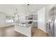 Open kitchen with island, granite counters, stainless appliances, and wood floors at 3718 Mossy Limb Ct, Palmetto, FL 34221
