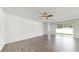 Spacious living room with wood flooring, fan, and sliding glass doors for ample natural light at 3718 Mossy Limb Ct, Palmetto, FL 34221