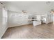 Open-concept living room boasts wood-look floors, neutral walls, and a view into the kitchen with grey cabinets at 3718 Mossy Limb Ct, Palmetto, FL 34221