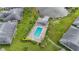 Aerial view of the community pool, deck, and jacuzzi surrounded by palm trees and single story homes at 5525 Bountiful Dr # 20, Sarasota, FL 34233