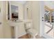 Powder room with a pedestal sink, a toilet, tile flooring, and a door to the outdoor pool at 650 Crane Prairie Way, Osprey, FL 34229