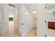 Hallway with tile flooring and white doors leading to various rooms at 650 Crane Prairie Way, Osprey, FL 34229