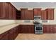 Kitchen features stainless steel appliances, cherry wood cabinets, and tile backsplash at 650 Crane Prairie Way, Osprey, FL 34229