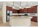 Kitchen features an island, stainless steel appliances, and ample dark wood cabinetry at 650 Crane Prairie Way, Osprey, FL 34229