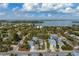 Aerial view showcasing a light gray house, surrounded by lush tropical foliage, in a waterfront community at 6940 Longboat S Dr, Longboat Key, FL 34228