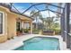 Outdoor living space featuring a screened lanai, heated pool, and lush tropical landscaping at 7116 Presidio Gln, Lakewood Ranch, FL 34202