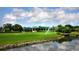 Community clubhouse with a green lawn and pond at 7547 Silver Fern Blvd # 54, Sarasota, FL 34241