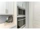 Modern kitchen with built-in oven and microwave, quartz countertops, and white cabinets at 9281 Ballaster Pointe Loop, Parrish, FL 34219