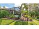 Landscaped backyard with a screened-in pool and lush tropical plants at 9291 Swaying Branch Rd, Sarasota, FL 34241