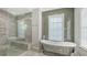 Bathroom with a walk-in shower, soaking tub and a circular window at 9291 Swaying Branch Rd, Sarasota, FL 34241