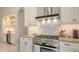 Kitchen with stainless steel range, white cabinets and marble backsplash at 9291 Swaying Branch Rd, Sarasota, FL 34241