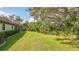 Landscaped side yard with mature trees and lush greenery at 9291 Swaying Branch Rd, Sarasota, FL 34241