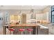 Modern kitchen with L-shaped island, red barstools, and a wood countertop at 9291 Swaying Branch Rd, Sarasota, FL 34241