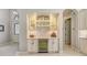 Built-in wet bar with wine cooler, glass shelving, and marble backsplash at 9291 Swaying Branch Rd, Sarasota, FL 34241