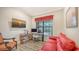 Home office with red couch, wooden chair, and a view of the pool at 9291 Swaying Branch Rd, Sarasota, FL 34241