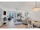Spacious living room with hardwood floors and balcony access at 2100 Benjamin Franklin Dr # 205, Sarasota, FL 34236