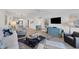 Open concept living room with kitchen view and access to balcony at 2100 Benjamin Franklin Dr # 205, Sarasota, FL 34236