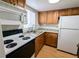 Compact kitchen with white appliances, wood cabinets, and light countertops at 1570 Pleasant Rd # J-26, Bradenton, FL 34207