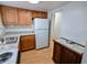 Kitchen boasts white appliances, wood cabinets, and light countertops at 1570 Pleasant Rd # J-26, Bradenton, FL 34207