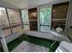 Bright sunroom with sliding doors, several windows, and artificial turf flooring at 1570 Pleasant Rd # J-26, Bradenton, FL 34207