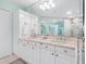 Double vanity bathroom with white cabinets and a large mirror at 3070 Grand Bay Blvd # 632, Longboat Key, FL 34228