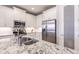 Modern kitchen featuring stainless steel appliances, granite countertops, white cabinetry, and a stylish faucet at 3127 Trustee Ave, Sarasota, FL 34243