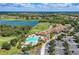 Stunning aerial view of the community featuring a pool, golf course, lake, clubhouse, and parking at 6547 Willowshire Way, Bradenton, FL 34212