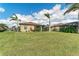 Large backyard with healthy green grass, a patio, palm trees, and tropical landscaping at 6547 Willowshire Way, Bradenton, FL 34212