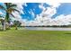 Lush backyard with a serene lake and palm trees, offering a tranquil outdoor space at 6547 Willowshire Way, Bradenton, FL 34212