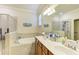 Bathroom features a soaking tub, tiled walk-in shower, and double sink vanity at 6547 Willowshire Way, Bradenton, FL 34212