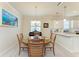 Dining area with round wood table, natural light, and adjoining kitchen at 6547 Willowshire Way, Bradenton, FL 34212