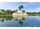 A view of the Heritage Harbor entrance sign featuring water and tropical trees at 6547 Willowshire Way, Bradenton, FL 34212