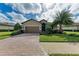 Inviting home showcasing a brick driveway, lush lawn, and mature landscaping, creating a welcoming atmosphere at 6547 Willowshire Way, Bradenton, FL 34212