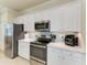 Bright kitchen featuring stainless steel appliances, white cabinets, and light countertops at 6547 Willowshire Way, Bradenton, FL 34212