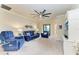 Cozy living room featuring blue sofa, chairs, and a large ceiling fan at 6547 Willowshire Way, Bradenton, FL 34212
