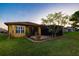 Backyard view of a yellow house with patio and pergola at 6935 74Th Street E Cir, Bradenton, FL 34203