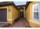 Front entrance of a yellow house with walkway at 6935 74Th Street E Cir, Bradenton, FL 34203