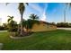 Exterior view of a yellow house with palm trees and a lawn at 6935 74Th Street E Cir, Bradenton, FL 34203