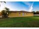 Side view of a yellow house with a green lawn at 6935 74Th Street E Cir, Bradenton, FL 34203