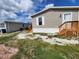 Tan home with white trim, featuring a tidy exterior and wooden stairs to the front door at 705 50Th Avenue W Dr, Bradenton, FL 34207