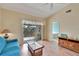 Cozy living room with vaulted ceilings, laminate flooring, ceiling fan, and sliding doors to a balcony at 7201 29Th Avenue W Dr # 309, Bradenton, FL 34209